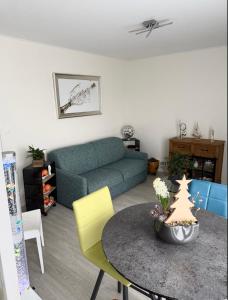 ein Wohnzimmer mit Sofa und Tisch in der Unterkunft Escale Berckoise Studio Cosy Proche des Phoques in Berck-sur-Mer