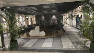 a lobby with tables and chairs and palm trees at Love Kush Hotel in Kishangarh