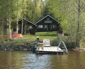 een huis aan de oever van een rivier met een dok bij Pohja in Joensuu