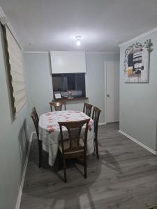 a dining room with a table and chairs and a kitchen at Villa Parque Cordillera 1 in Chillán