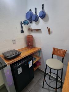a kitchen with a counter and a chair and a table at Suíte de Marcio in Itacaré