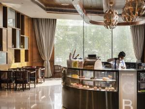 a woman standing behind a counter in a restaurant at Novotel Vijayawada Varun in Vijayawāda +107 photos