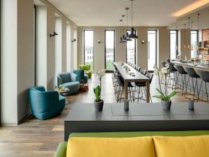 a restaurant with blue and green chairs and tables at Aparthotel Adagio Bremen City in Bremen