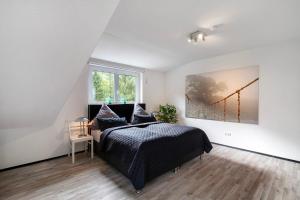 een slaapkamer met een bed en een schilderij aan de muur bij Villa Eichwald Appartements in Freudenstadt