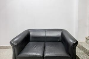 a black leather couch sitting in a living room at Collection O Sector 18 Noida Formerly True Residency in Okhla