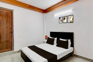a bedroom with a bed with white walls at Collection O Sector 18 Noida Formerly True Residency in Okhla