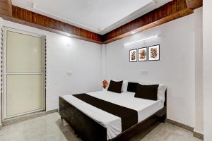 a bedroom with a large bed with white walls at Collection O Sector 18 Noida Formerly True Residency in Okhla +22 photos