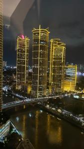 a city skyline at night with a river and buildings at Novotel Suites Celestia at Hotel Residences Manila in Manila