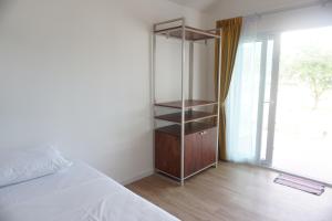 a bedroom with a wooden cabinet and a window at Travellers Palm in Koh Phangan