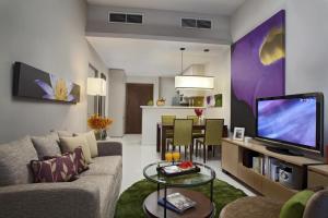 a living room filled with furniture and a tv at Somerset Kuala Lumpur in Kuala Lumpur