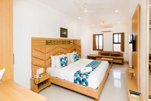 een slaapkamer met een groot bed en een televisie bij HOTEL GALAXY SURAT in Surat +17 foto's