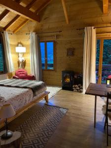 een slaapkamer in een blokhut met een bed en een open haard bij Chalet la Cabane d'Ernestine, petit-déjeuner inclus in Les Villards-sur-Thônes