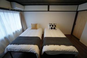 due letti uno accanto all'altro in una stanza di Katata Biwa House a Otsu Altre 45 foto