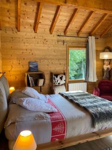 een slaapkamer met een bed in een blokhut bij Chalet la Cabane d'Ernestine, petit-déjeuner inclus in Les Villards-sur-Thônes