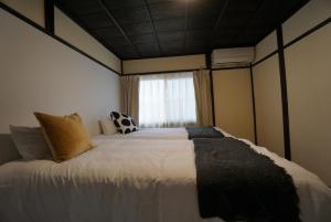 una camera da letto con un grande letto bianco con una finestra di Katata Biwa House a Otsu