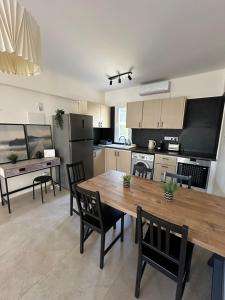 a large kitchen with a wooden table and chairs at Mari House-close to the beach in Paphos