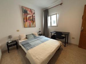 a bedroom with a bed and a desk in it at MarMontaña in Arinaga