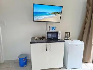 Camera dotata di scrivania con computer portatile e TV a parete. di Rembrandt a Ballito