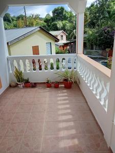 un balcon avec des plantes en pot et une clôture blanche dans l'établissement Cassiane apartments, à Thibaud