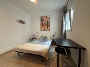 a bedroom with a bed and a desk in it at MarMontaña in Arinaga