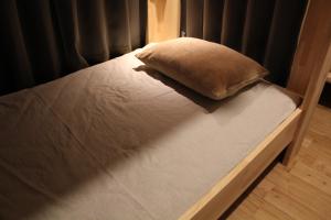 un letto con un cuscino sopra di Nara Guesthouse Kamunabi a Nara