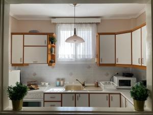 a kitchen with white cabinets and a sink at Zoel's House in Chalkidiki in Agia Paraskevi