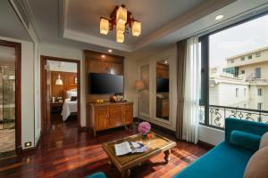 ein Wohnzimmer mit einer blauen Couch und einem Fernseher in der Unterkunft Hanoi Pearl Hotel in Hanoi