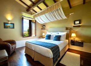 een slaapkamer met een groot bed met blauwe kussens bij L'Olmo in Monticchiello +33 foto's