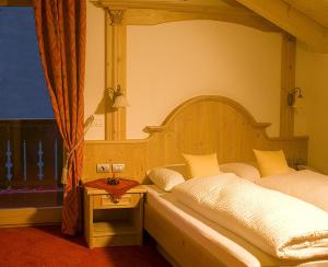 Schlafzimmer mit Himmelbett und Fenster in der Unterkunft Residence Rumanon in St. Ulrich in Gröden