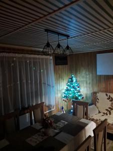 a christmas tree in a dining room with a table and a christmas tree at Domek w górach Wioletta in Rycerka Górna +19 photos