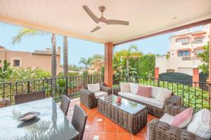 een patio met stoelen, een tafel en een plafondventilator bij Pareado Relax in Marbella