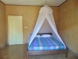 een bed met een hemelbed in een kamer bij Brother Bungalow in Gili Trawangan