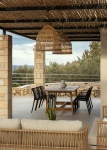 a patio with a wooden table and chairs at Plaka Oasis - Private Pool - Walk to Beach & Shops in Plaka +34 photos