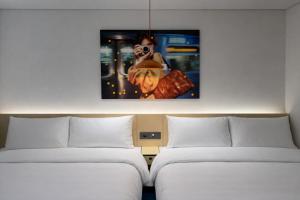 a room with two beds and a picture on the wall at Fritta Hotel in Suwŏn-yŏk