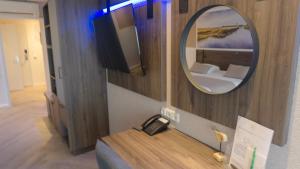 a hotel room with a mirror and a bed at Hotel Zwartewater in Zwartsluis