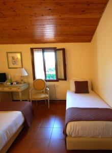 une chambre avec deux lits et un bureau et une fenêtre dans l'établissement Hotel Antica Fenice, à Campalto