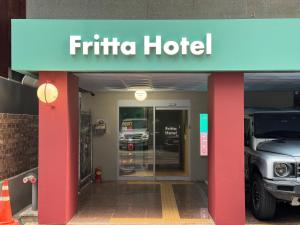 a hotel with a truck parked outside of it at Fritta Hotel in Suwŏn-yŏk