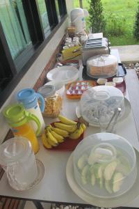 a table with plates of food and fruit on it at Sweet Dreams in Phetchaburi