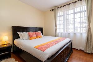 a bedroom with a large bed with a window at Royal Homes in Nairobi +52 photos