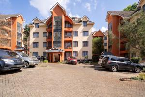 a large apartment building with cars parked in a parking lot at Royal Homes in Nairobi