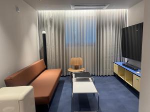 a room with a couch and a chair and a television at Fritta Hotel in Suwŏn-yŏk +7 photos