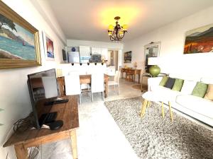 a living room with a white couch and a tv at t3 cagnes sur mer in Cagnes-sur-Mer