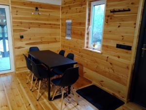 a dining room with wooden walls and a table and chairs at Miodowa cisza in Szafarnia