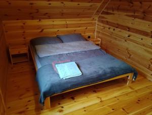 a bed in a room in a log cabin at Miodowa cisza in Szafarnia