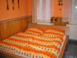a bed with an orange and white comforter and pillows at Chalupa u Jizery in Rokytnice nad Jizerou