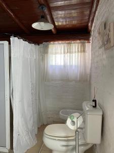 a white bathroom with a toilet and a window at Casita campestre in Cacheuta +22 photos