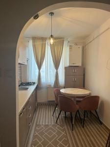 een keuken met een tafel en twee stoelen en een tafel bij EVA - Apartament in Cîmpulung +12 foto's