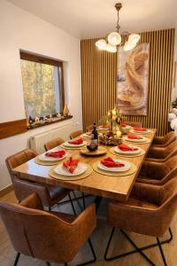 a dining room table with chairs and a large wooden table at Cazare Colibița Casa Lipan cu jacuzzi, foișor și loc de joacă in Colibiţa