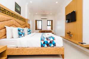 a bedroom with a large bed and a flat screen tv at HOTEL GALAXY SURAT in Surat
