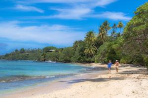 a couple walking on the beach at Vacala Bay Resort in Matei